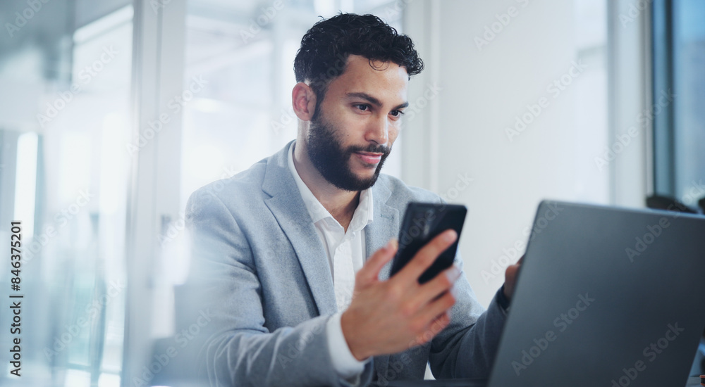 Office, phone and business man on laptop for online networking, website and internet at desk. Corporate, professional and person on smartphone and computer for research, communication and email Office, phone and business man on laptop for online networking, website and internet at desk. Corporate, professional and person on smartphone and computer for research, communication and email