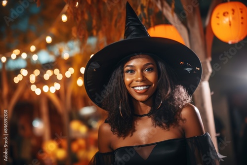 A transgender person wearing a witch costume and smiling at a Halloween event