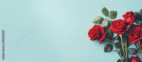 A creative flat lay arrangement featuring red flowers and a pastel blue background Perfect for Women s Day or Valentine s Day with ample copy space The minimalistic spring concept highlights the beau