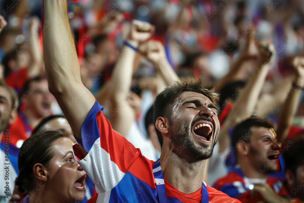 Soccer fans in vivid colors raise their arms in unity at a sports event, displaying team spirit and excitement Soccer fans in vivid colors raise their arms in unity at a sports event, displaying team spirit and excitement