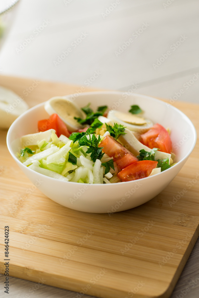 fresh vegetable salad, cabbage, tomatoes in a bowl on a wooden table fresh vegetable salad, cabbage, tomatoes in a bowl on a wooden table