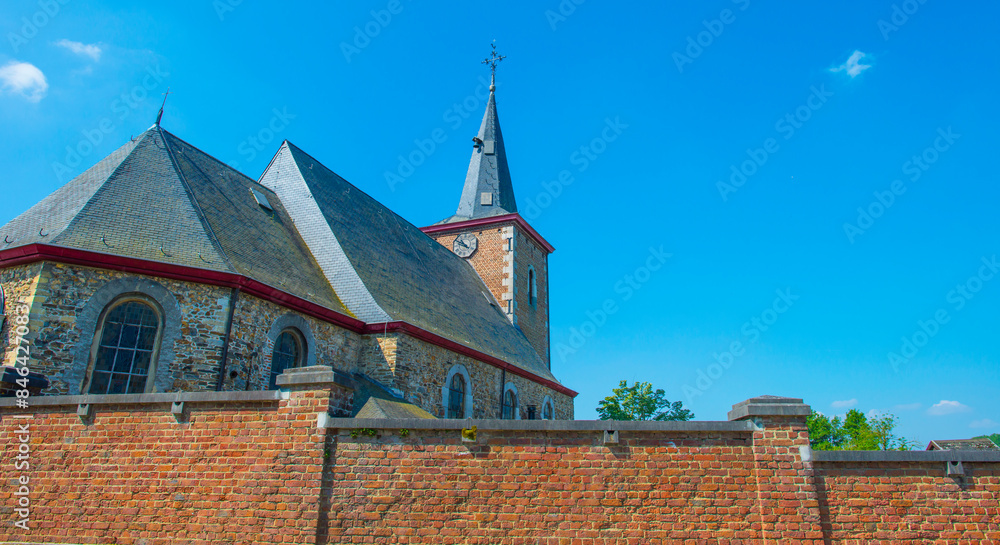 Trees and an old church in sunlight in summer, Voeren, Limburg, Belgium, June, 2024