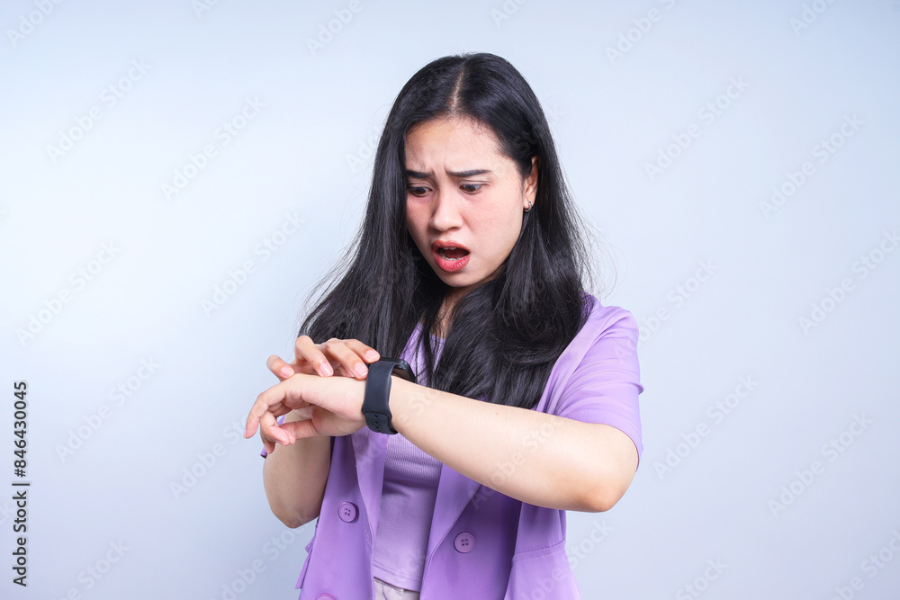 Portrait of a shocked young woman looking at her wrist watch isolated over white background Portrait of a shocked young woman looking at her wrist watch isolated over white background