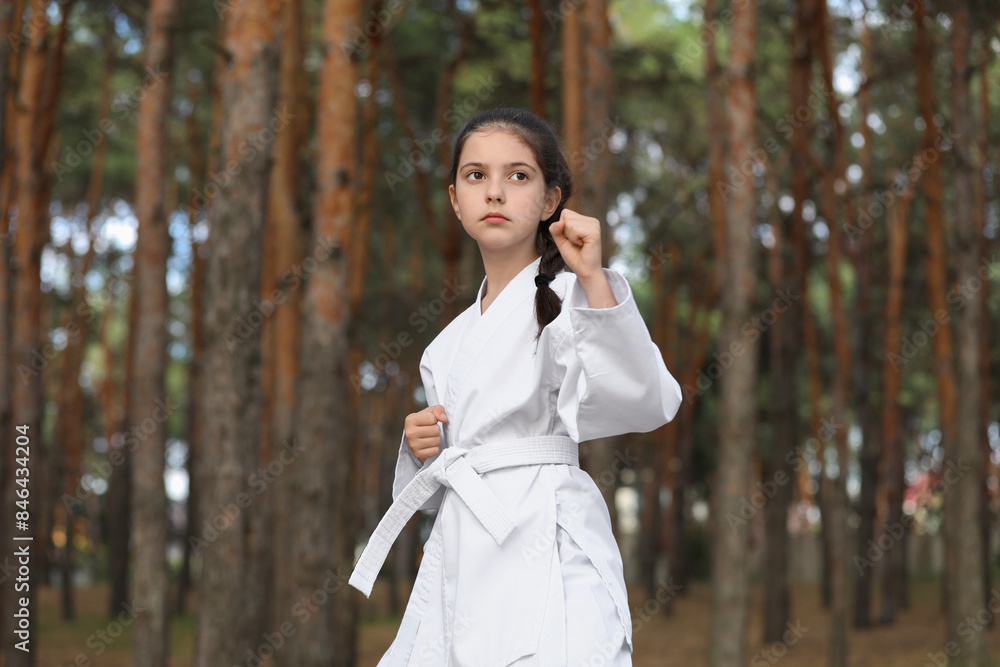 Cute little girl in kimono practicing karate in forest Cute little girl in kimono practicing karate in forest