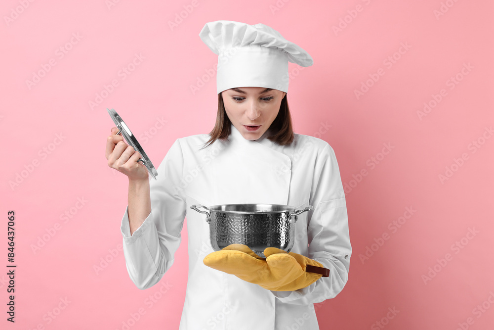 Professional chef with cooking pot on pink background Professional chef with cooking pot on pink background