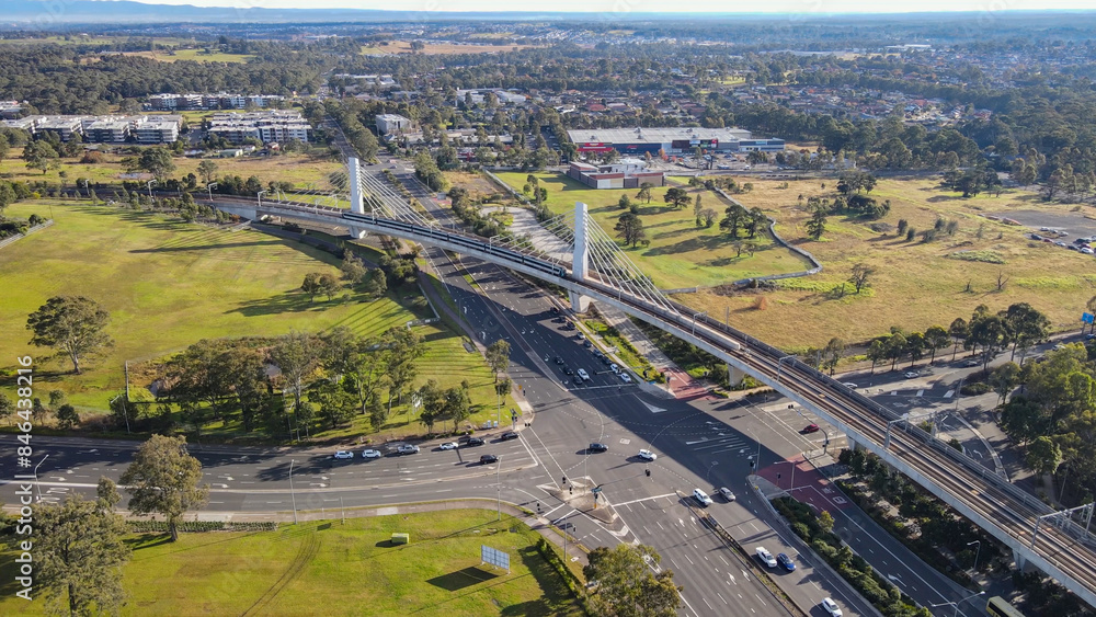 Aerial drone view of a train heading toward Tallawong Station on the metro northwest railway line, Greater Sydney, NSW Australia crossing the railway bridge in June 2024 Aerial drone view of a train heading toward Tallawong Station on the metro northwest railway line, Greater Sydney, NSW Australia crossing the railway bridge in June 2024