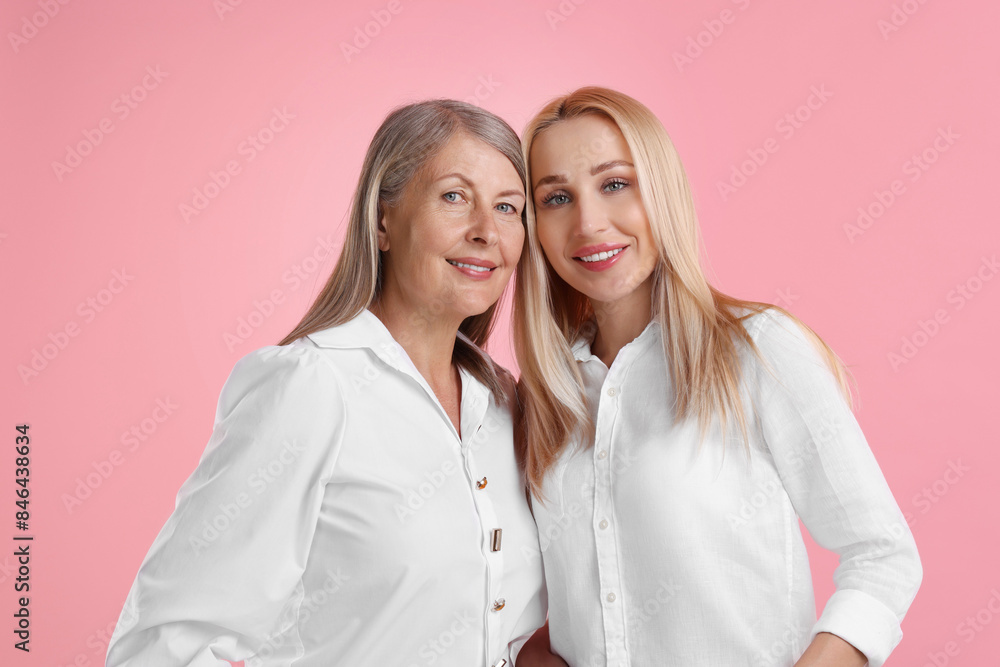 Family portrait of young woman and her mother on pink background Family portrait of young woman and her mother on pink background
