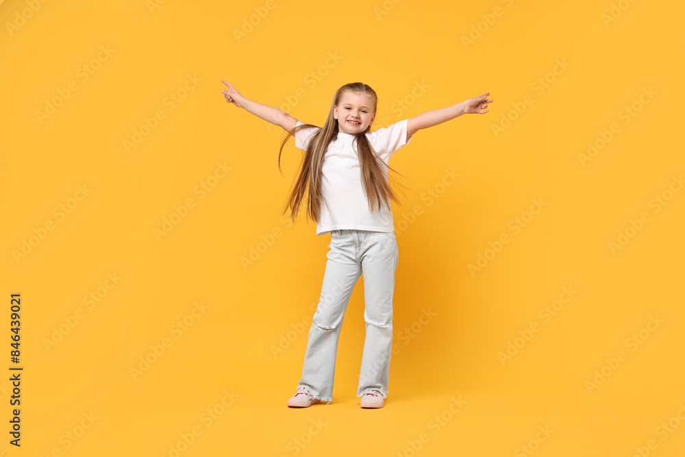 Cute little girl dancing on yellow background Cute little girl dancing on yellow background