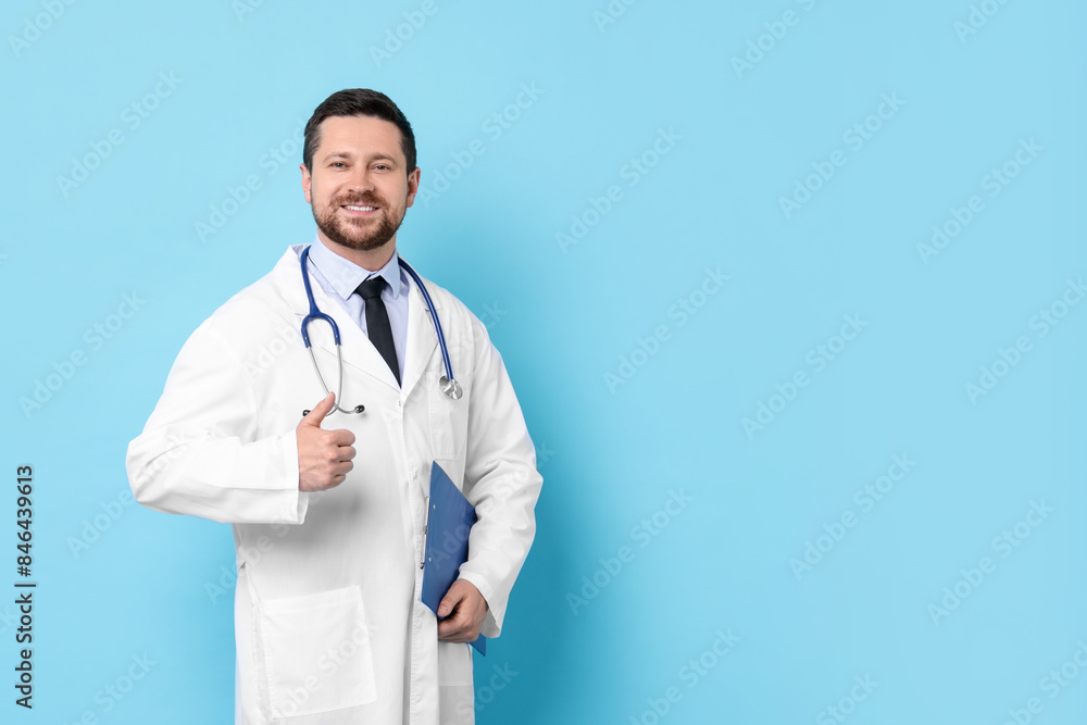 Doctor with clipboard showing thumbs up against light blue background. Space for text Doctor with clipboard showing thumbs up against light blue background. Space for text