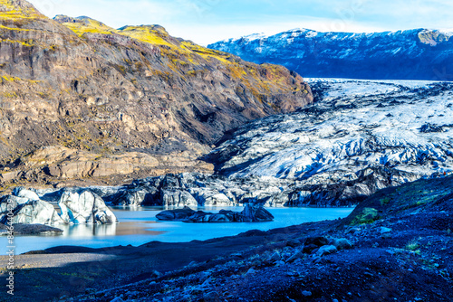 A beautiful landscape with a large body of water and Solheimajokull glacier, Iceland photo