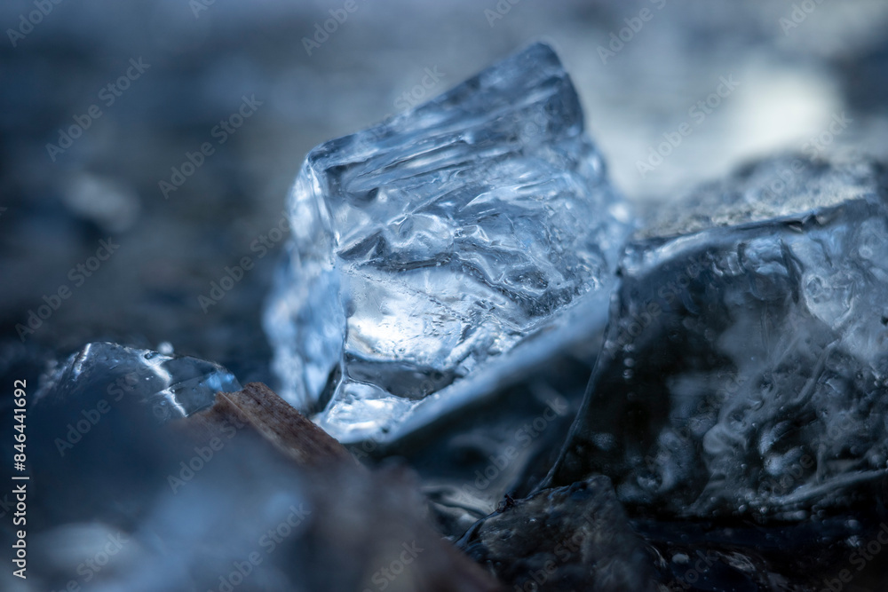 Ice chunks on the ground near a small pile Ice chunks on the ground near a small pile