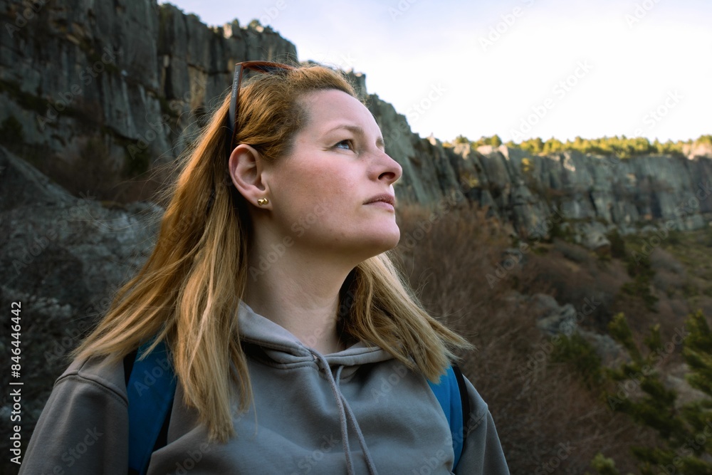 Young woman poses against a mountain backdrop Young woman poses against a mountain backdrop