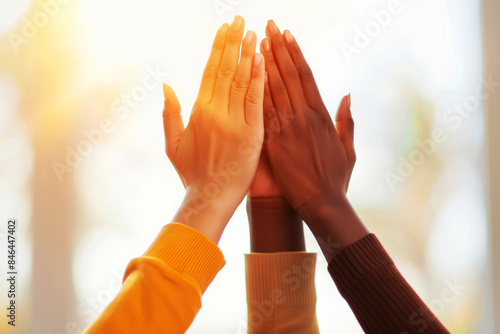 Close-up of diverse hands high fiving unity and teamwork in a bright, sunny environment