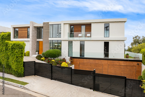 Contemporary house on a corner lot with lush foliage © Wirestock