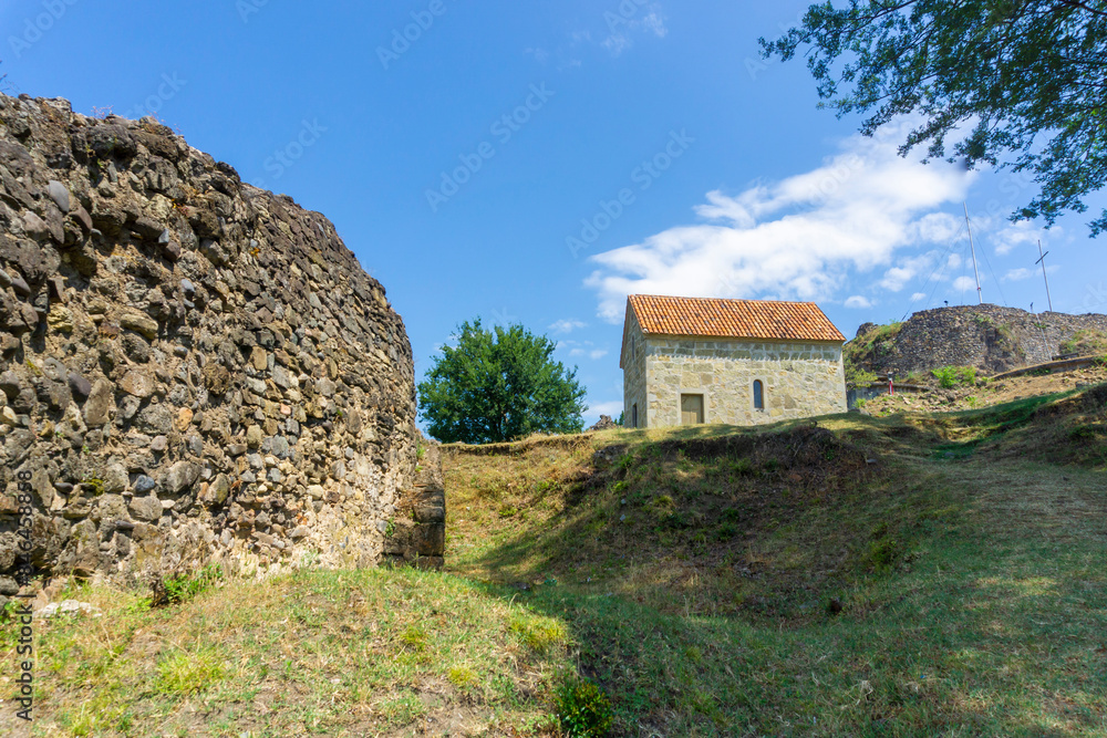 Small church in the courtyard of Shorapani fortress. Light stone walls and orange tiled roof Small church in the courtyard of Shorapani fortress. Light stone walls and orange tiled roof