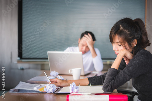 A bored business woman sitting behind a pile of files  boring work hard at meeting room concept.