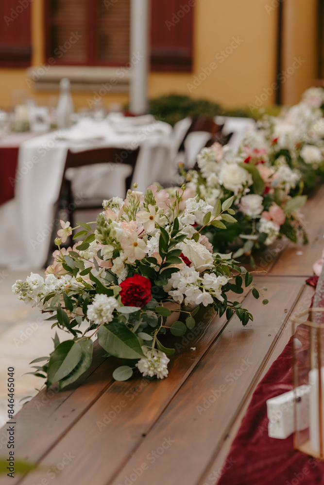 floral wedding centerpieces are lined up along the length of a table floral wedding centerpieces are lined up along the length of a table