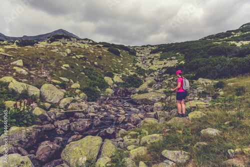 Female hiker in a pink shirt on a rocky mountain trail photo