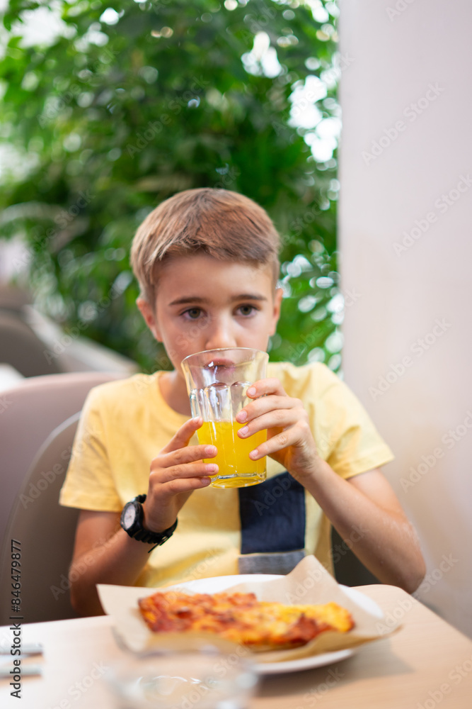 8 year old Caucasian boy drinking an orange soda 8 year old Caucasian boy drinking an orange soda
