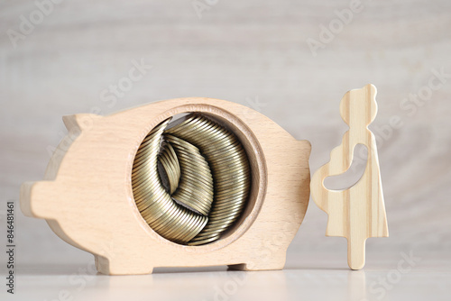 Pregnant woman with piggy bank and gold coin money on wooden background,Save money for prepare in future and newborn baby concept photo