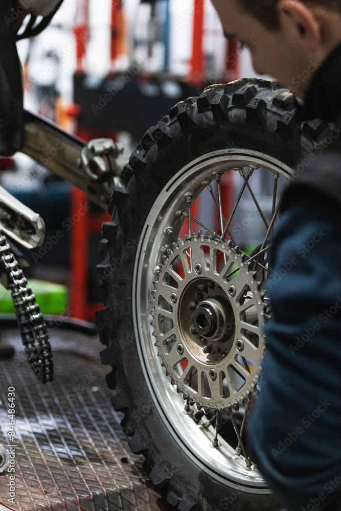 Fototapeta premium mechanic fixing motocycle wheel