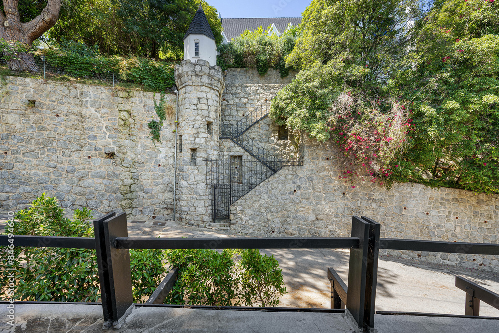 Stone building with a staircase and a tower surrounded by lush greenery. California Stone building with a staircase and a tower surrounded by lush greenery. California
