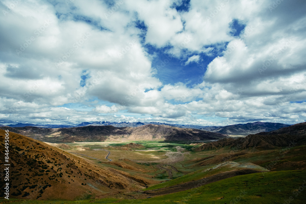 A Majestic Mountain Valley with Rolling Hills and Dramatic Clouds A Majestic Mountain Valley with Rolling Hills and Dramatic Clouds
