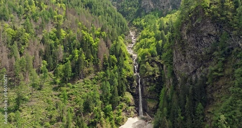 Aerial view of a waterfall in the Dolomite Alps, Italy. The natural landscape of the river flows through the canyon and falls down in the mountains. High quality 4k footage photo