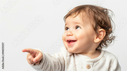Adorable baby with curly hair, pointing and smiling with joy. Perfect for themes of childhood, happiness, and innocence