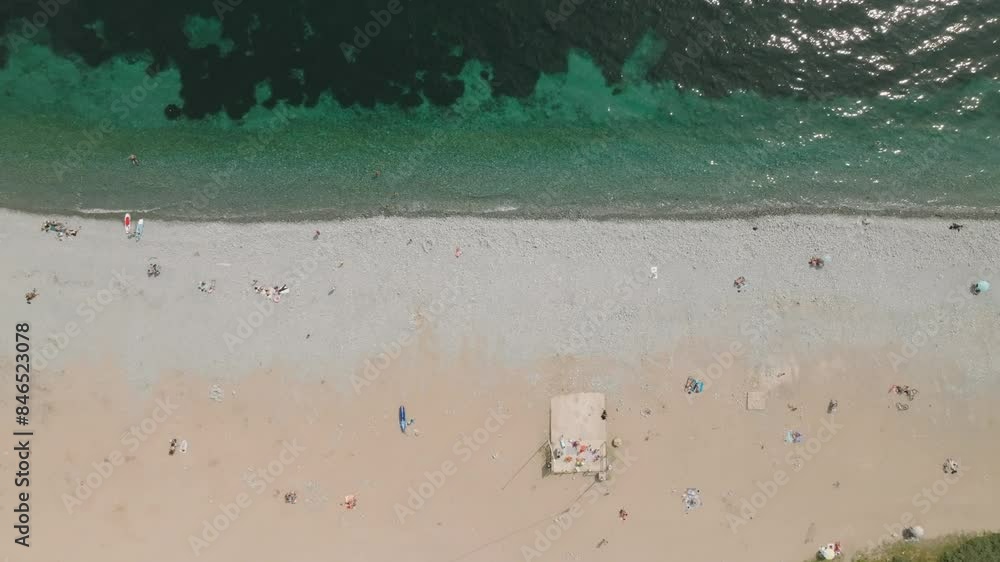 People sunbathing and relaxing near the sparkling waters of the sea at Le Dramont Beach, France. People sunbathing and relaxing near the sparkling waters of the sea at Le Dramont Beach, France.