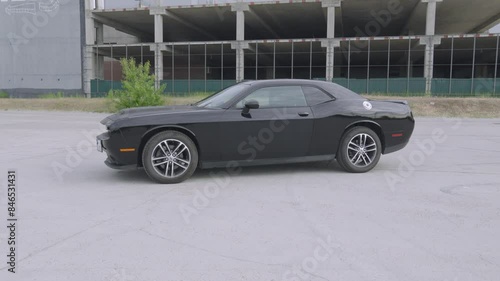 Iconic Black Dodge Challenger, embodying American muscle car prowess, in this thrilling video. photo