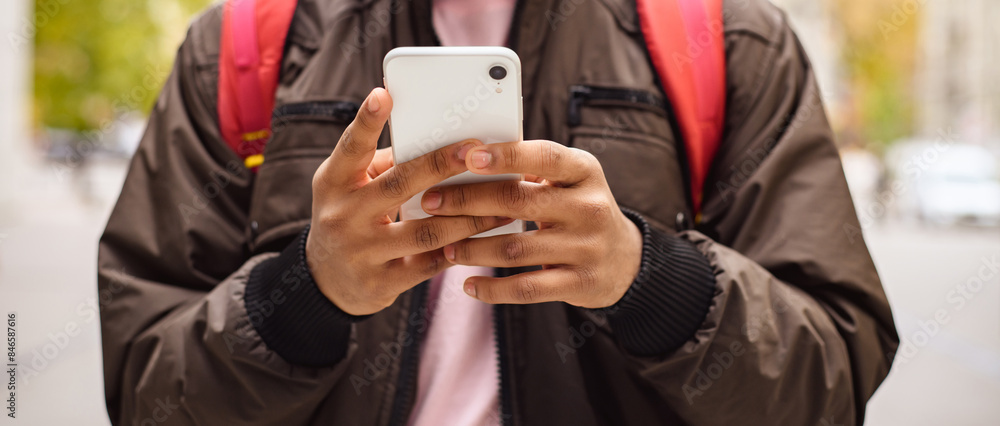 Faseless shot of indian man using smartphone on urban street, web banner Faseless shot of indian man using smartphone on urban street, web banner
