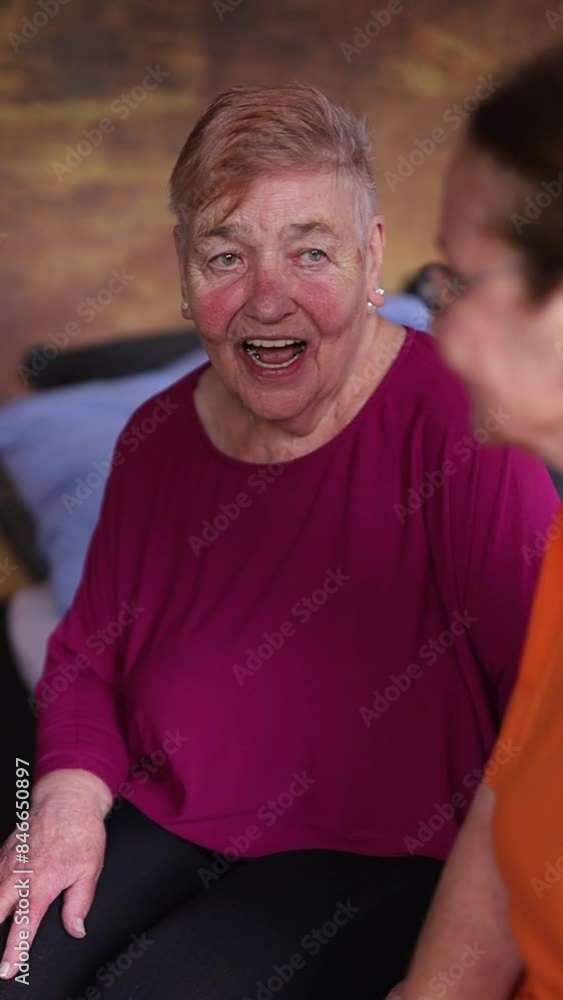 A female nurse checks an elderly man's blood sugar levels while sitting A female nurse checks an elderly man's blood sugar levels while sitting