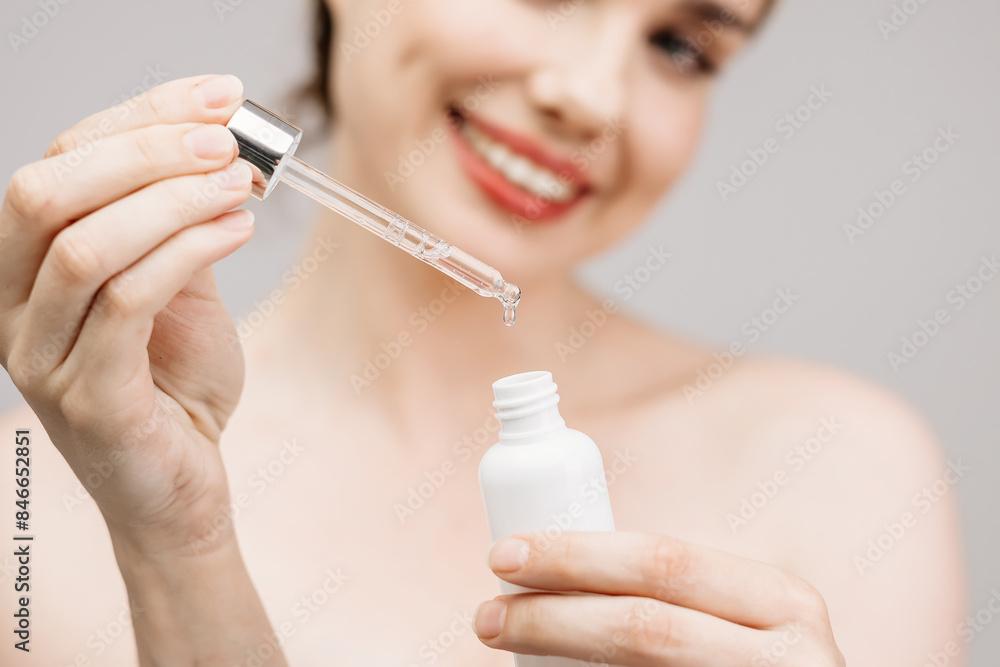 Skin care and rejuvenation. A beautiful blonde woman on a light background holds a cosmetic skin care product in her hands. Hydration with serum collagen and hyaluronic acid. Skin care and rejuvenation. A beautiful blonde woman on a light background holds a cosmetic skin care product in her hands. Hydration with serum collagen and hyaluronic acid.