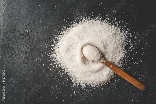 Wooden spoon with salt, splash, top view