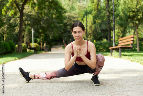 Young fitness woman runner stretching legs before run