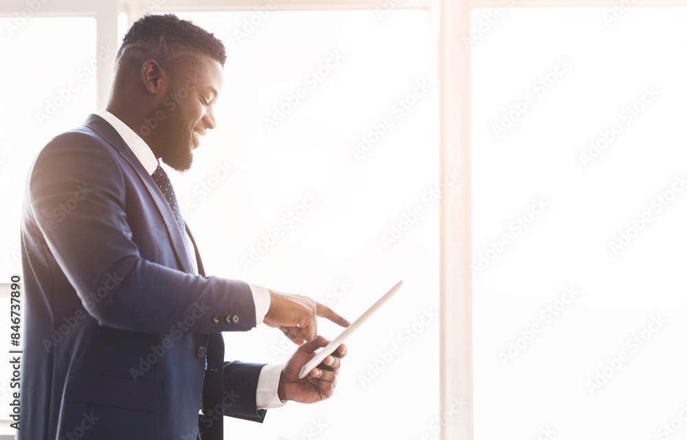 Cheerful african american entrepreneur using business application on digital tablet, talking to partners, empty space Cheerful african american entrepreneur using business application on digital tablet, talking to partners, empty space