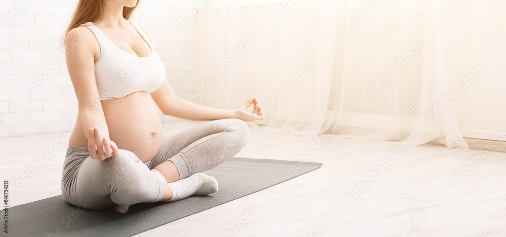 Pregnant yoga. Expectant woman meditating at home, sitting in lotus position, panorama with free space Pregnant yoga. Expectant woman meditating at home, sitting in lotus position, panorama with free space