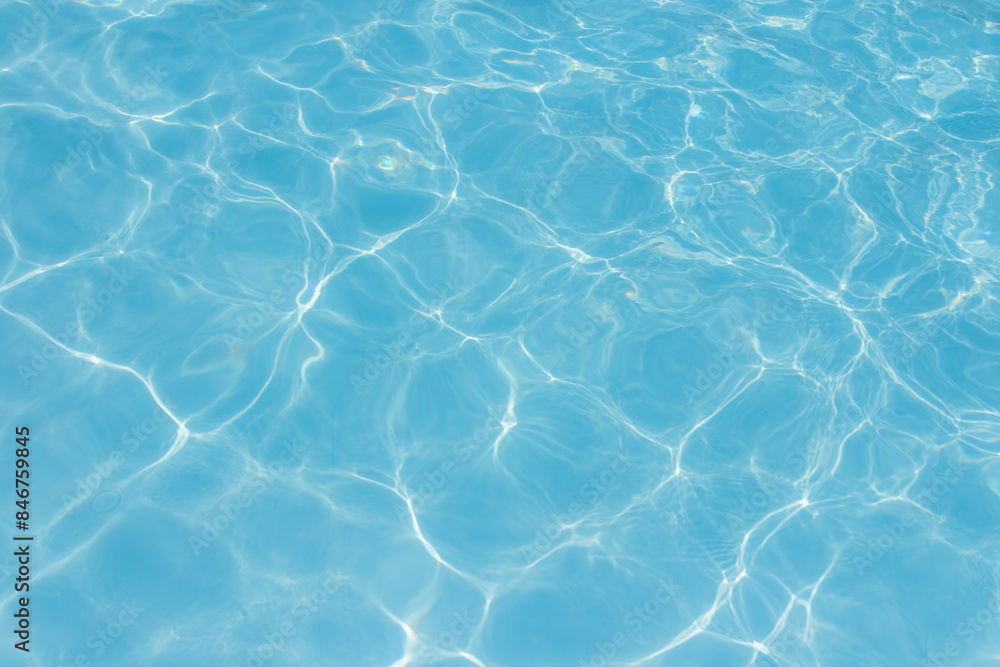 Clear blue swimming pool water surface with sunlight reflections creating abstract patterns and ripples, evoking a refreshing and tranquil summer vibe. Clear blue swimming pool water surface with sunlight reflections creating abstract patterns and ripples, evoking a refreshing and tranquil summer vibe.