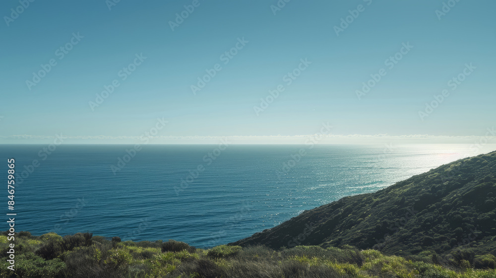 Clear horizon over ocean with lush green coastline Clear horizon over ocean with lush green coastline