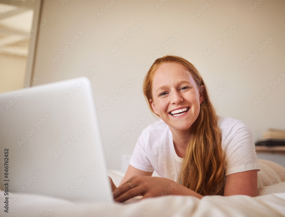 Fototapeta premium Girl, laptop and portrait for networking while on bed, searching and happy for browsing for movie. Home and smile at streaming site for entertainment, online in bedroom and post blog on website