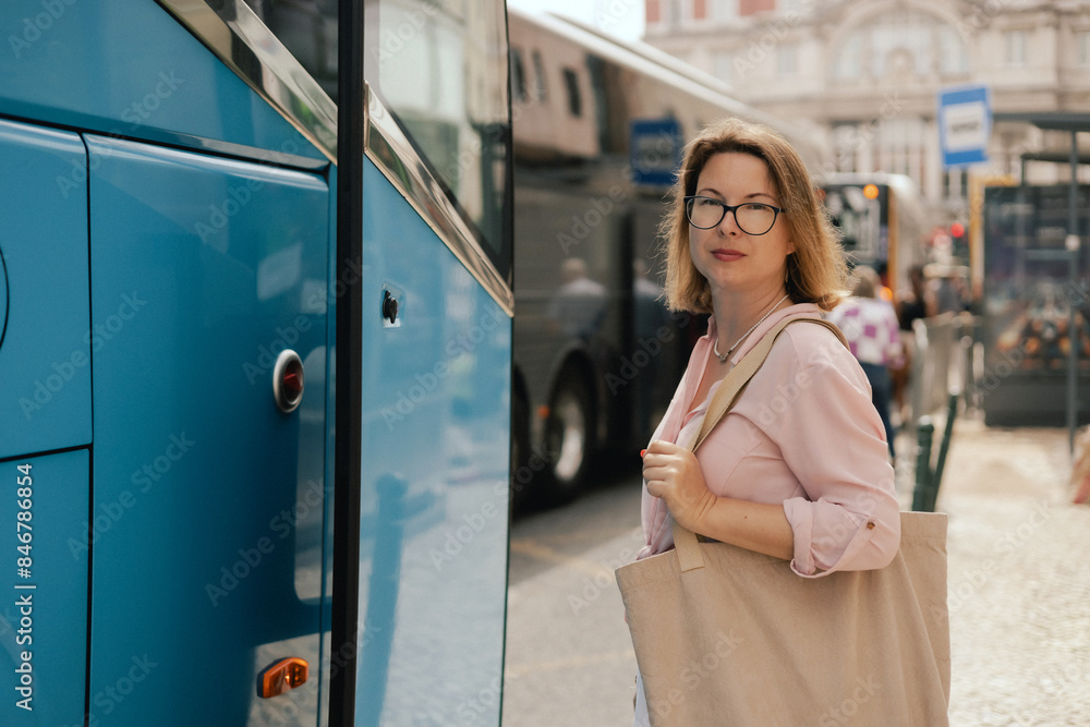 City travel and solo tourism concept. Tourist Woman is waiting for transport at the transport station. Copy space. Part of the series City travel and solo tourism concept. Tourist Woman is waiting for transport at the transport station. Copy space. Part of the series