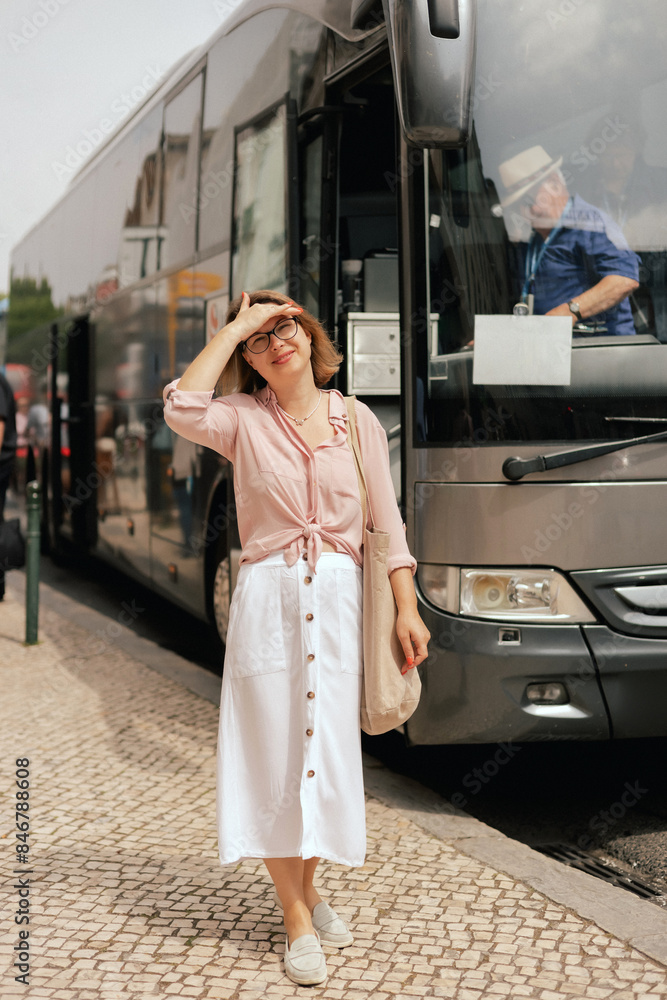 City travel and solo tourism concept. Tourist Woman is waiting for transport at the transport station. Copy space. Part of the series City travel and solo tourism concept. Tourist Woman is waiting for transport at the transport station. Copy space. Part of the series