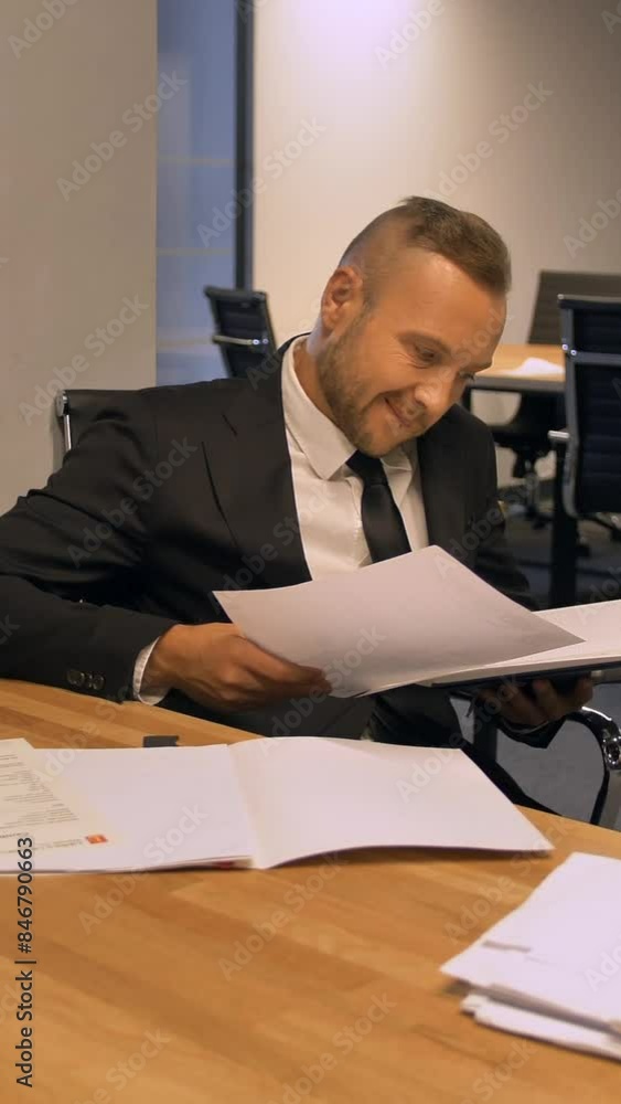 Confident boss entrepreneur working with documents in night office indoor. He attentively looking for important information 4k Ultra HD Slow motion. Vertical shot. Confident boss entrepreneur working with documents in night office indoor. He attentively looking for important information 4k Ultra HD Slow motion. Vertical shot.