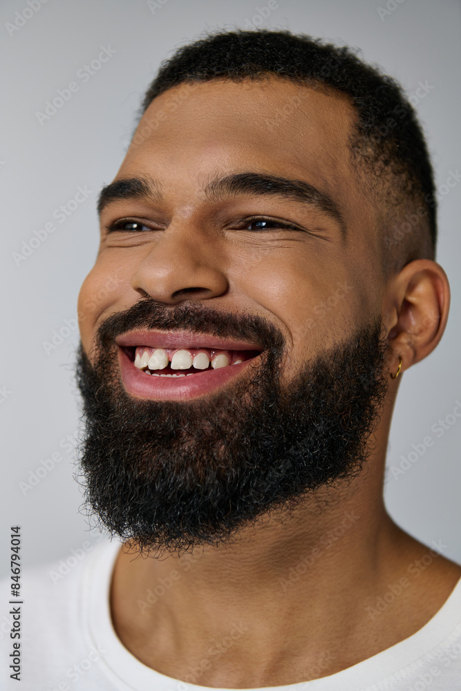 A young man with a beard smiling warmly at the camera. A young man with a beard smiling warmly at the camera.