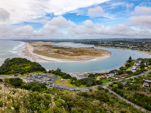 Aerial view over river bending around sandbank into the ocean in the beach town of Mangawhai, New Zealand