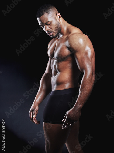 Black man, underwear and serious fitness in studio, strong arms and muscle on dark background. Male person, confidence and athlete for power or healthy body, bodybuilder and stomach for wellness