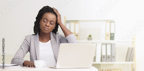 Foto African American businesswoman suffering from migraine at office setting, sittin