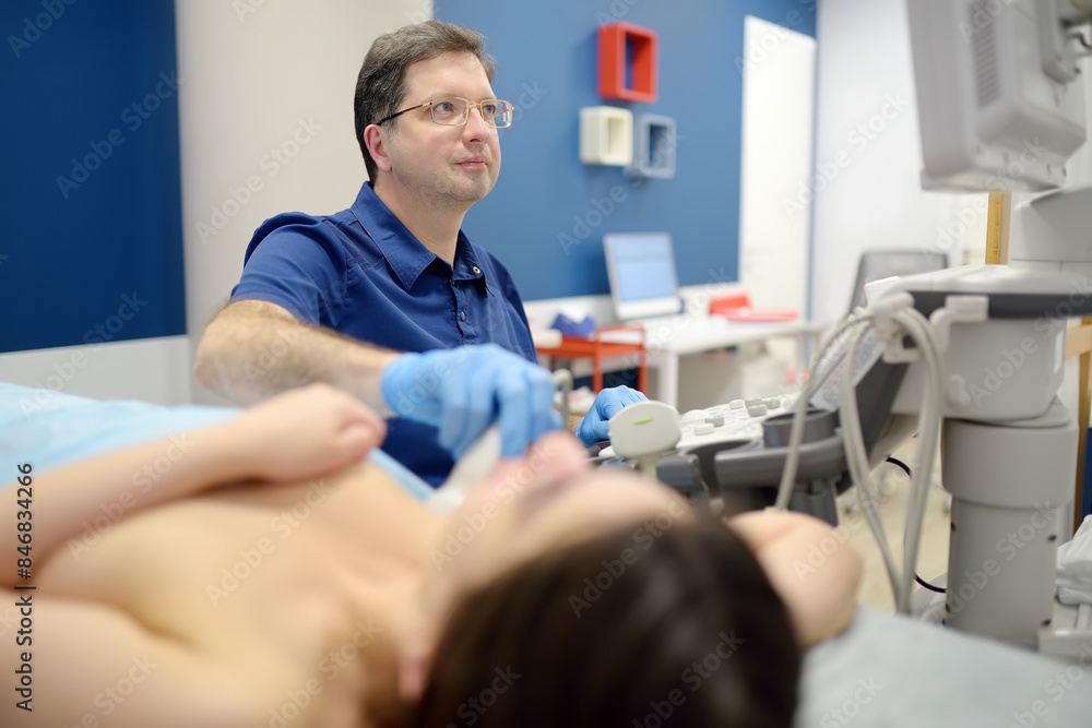 Obraz premium Mammologist doctor examines a woman breasts and lymph nodes using ultrasound. Mammography and ultrasound scanning are main methods of instrumental diagnosis of mammary glands. Breast cancer