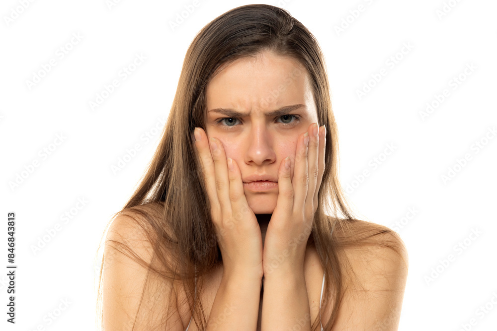 portrait of a young angry teenage girl without makeup on a white studio background portrait of a young angry teenage girl without makeup on a white studio background